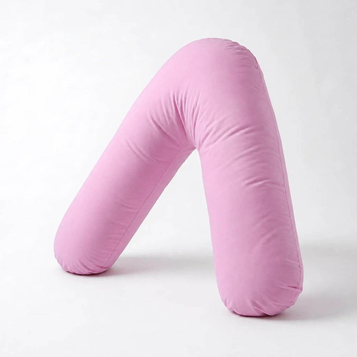 Pink Nurtura V-shaped support pillow with soft fabric, displayed upright against a white background